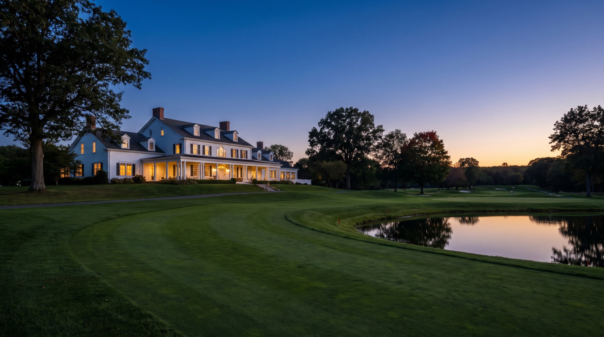 A country club clubhouse overlooking a fairway at dusk